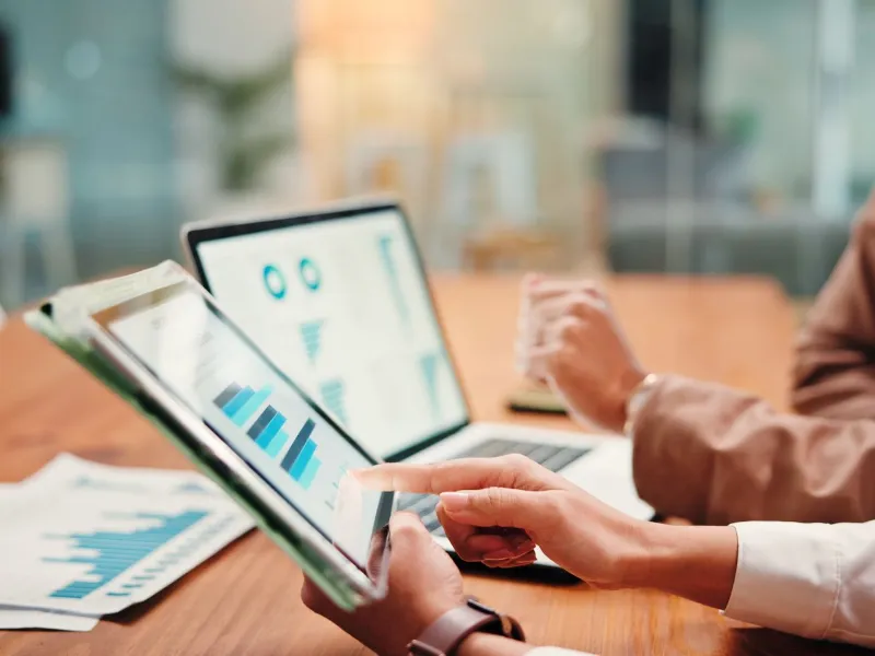 graphs on tablet screen for finance results, profit growth and budget review.